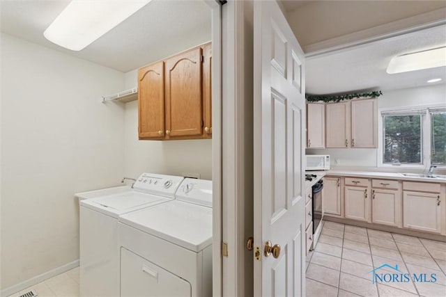 2016 Austin Bluffs Ct, Toledo, OH 43615 - washroom with light tile patterned floors, baseboards, a sink, independent washer and dryer, and cabinet space