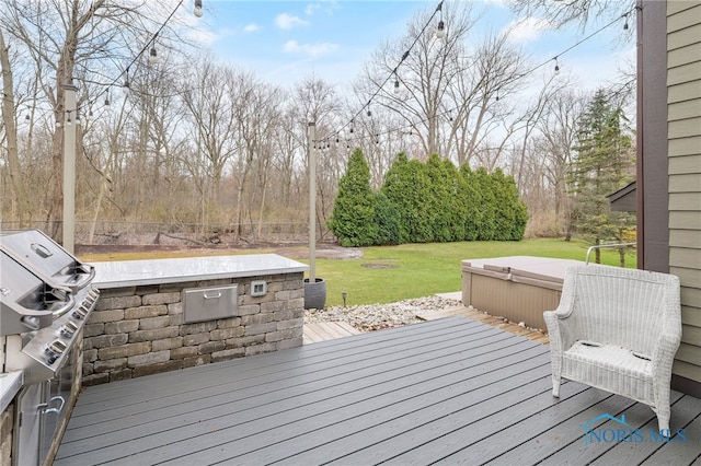 wooden deck featuring an outdoor kitchen, a yard, and fence