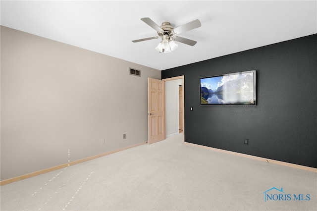 unfurnished room with light colored carpet, visible vents, ceiling fan, and baseboards