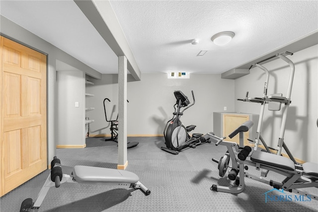 exercise area with baseboards and a textured ceiling
