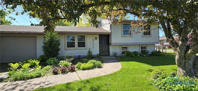 2260 Tracy Rd, Northwood, OH 43619 - view of front of property with a front yard, an attached garage, and stucco siding