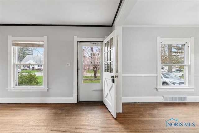 entryway featuring wood-type flooring, crown molding, and visible vents