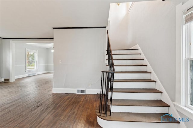 staircase with ceiling fan, baseboards, wood finished floors, and visible vents