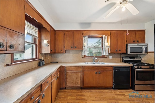 kitchen featuring stainless steel appliances, a sink, and brown cabinetry