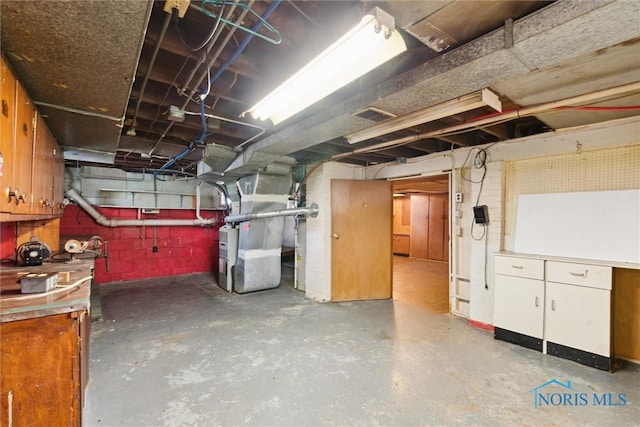 unfinished below grade area with visible vents and heating unit