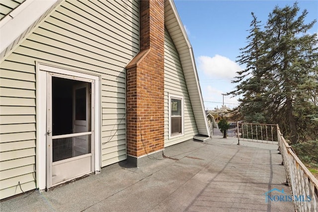 view of property exterior featuring a chimney and a patio