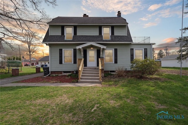 dutch colonial featuring a lawn, a shingled roof, and a chimney