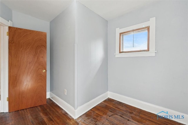 unfurnished room with hardwood / wood-style flooring and baseboards