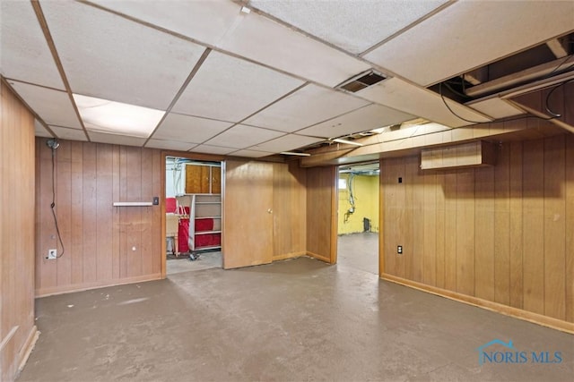 finished below grade area with wood walls, visible vents, and baseboards