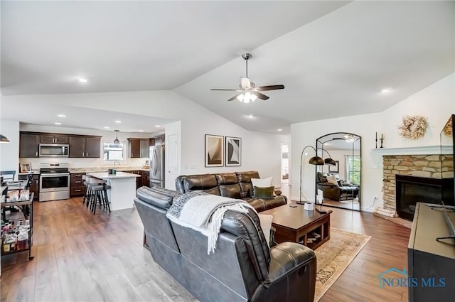 630 Weatherby Ct, Findlay, OH 45840 - living room featuring a ceiling fan, wood finished floors, a stone fireplace, lofted ceiling, and recessed lighting