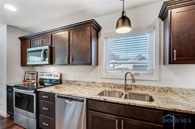 630 Weatherby Ct, Findlay, OH 45840 - kitchen with a sink, light stone countertops, hanging light fixtures, stainless steel appliances, and dark brown cabinets