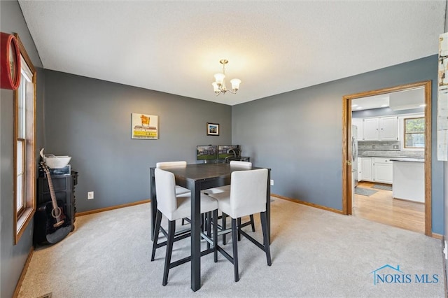3011 Heather Downs Dr, Findlay, OH 45840 - dining space with a chandelier, baseboards, and light colored carpet