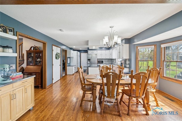 3011 Heather Downs Dr, Findlay, OH 45840 - dining space with baseboards, light wood-style floors, a notable chandelier, and visible vents