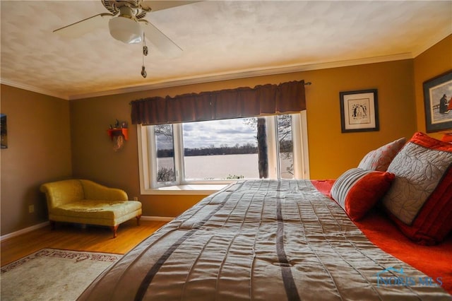 bedroom with baseboards, wood finished floors, and crown molding