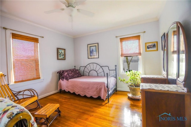 bedroom with baseboards, wood finished floors, ceiling fan, and ornamental molding