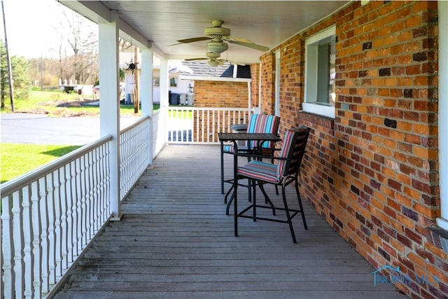 wooden deck with covered porch and a ceiling fan