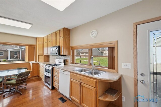 371 Canal Rd, Waterville, OH 43566 - kitchen with tasteful backsplash, appliances with stainless steel finishes, light countertops, a sink, and light wood finished floors