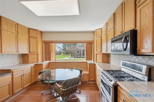 371 Canal Rd, Waterville, OH 43566 - kitchen with light countertops, wood finished floors, backsplash, and appliances with stainless steel finishes
