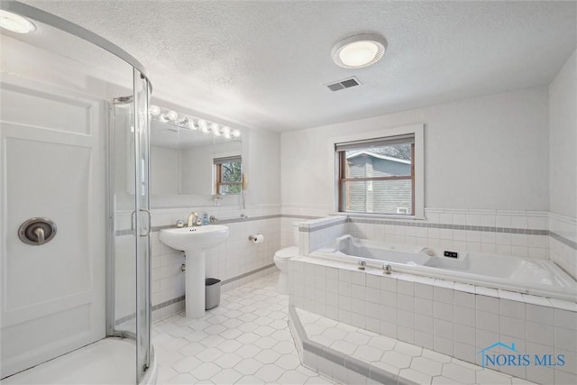 371 Canal Rd, Waterville, OH 43566 - full bathroom featuring tile patterned floors, a textured ceiling, a shower stall, visible vents, and a bath