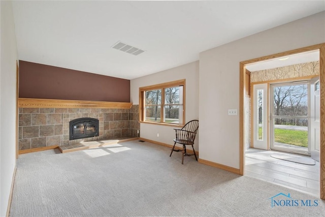 371 Canal Rd, Waterville, OH 43566 - unfurnished living room with a tiled fireplace, baseboards, carpet, and visible vents