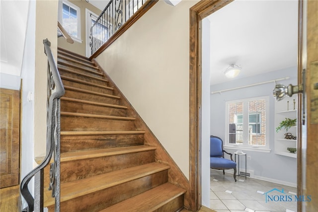 stairway featuring baseboards and tile patterned floors