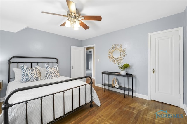 bedroom featuring baseboards, wood finished floors, and a ceiling fan