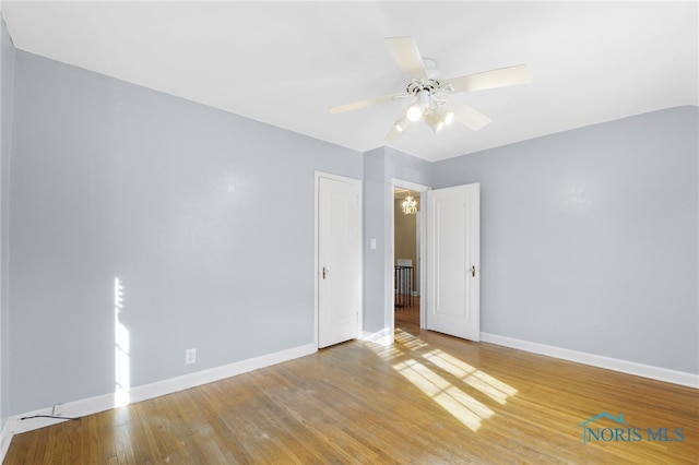 spare room featuring a ceiling fan, baseboards, and wood finished floors