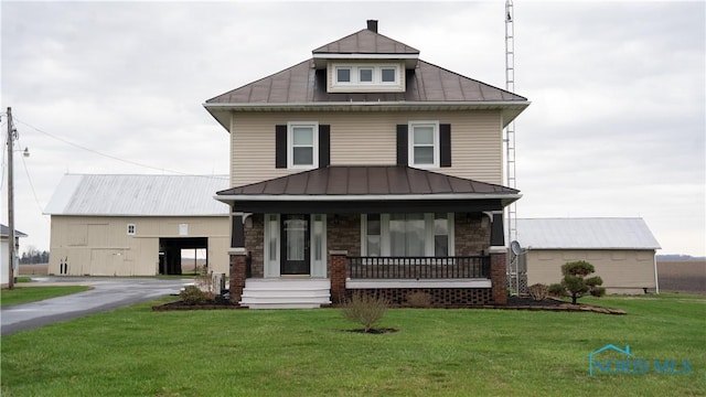 traditional style home featuring a standing seam roof, metal roof, stone siding, a front lawn, and a porch