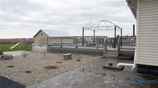 view of yard with a fenced in pool, a deck, and a playground