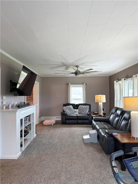 carpeted living area featuring baseboards and ceiling fan