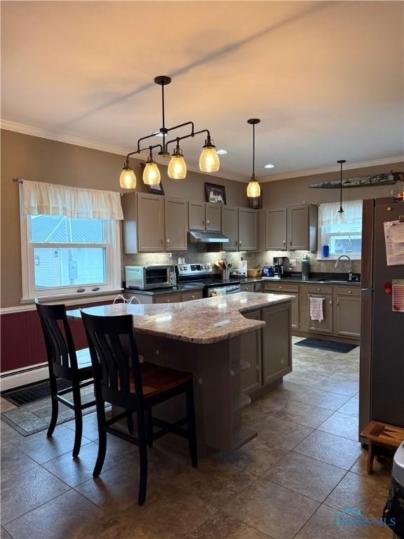 kitchen featuring under cabinet range hood, gray cabinetry, electric range, a center island, and freestanding refrigerator