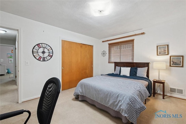 bedroom featuring baseboards, carpet, a closet, and visible vents