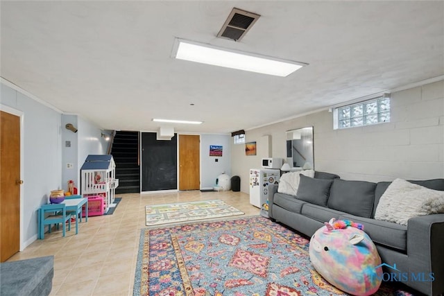 living room with concrete block wall, stairs, light tile patterned floors, ornamental molding, and visible vents
