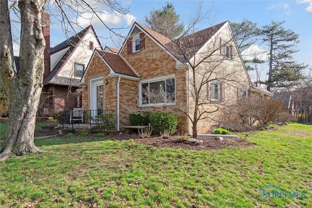 view of front of property featuring a front yard and brick siding
