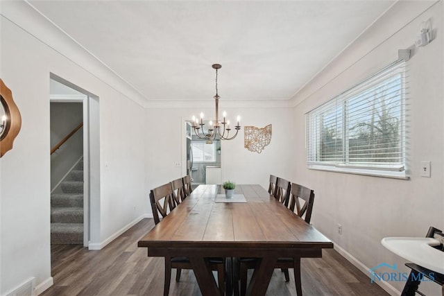 dining space with stairway, baseboards, visible vents, a notable chandelier, and wood finished floors