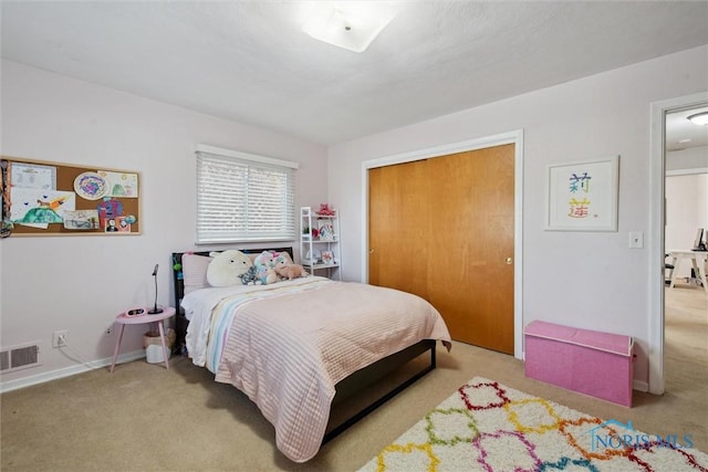 carpeted bedroom featuring baseboards, visible vents, and a closet