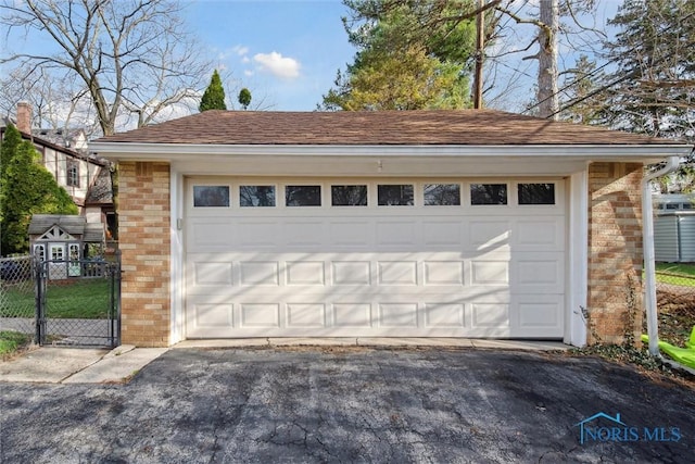 detached garage featuring a gate and fence