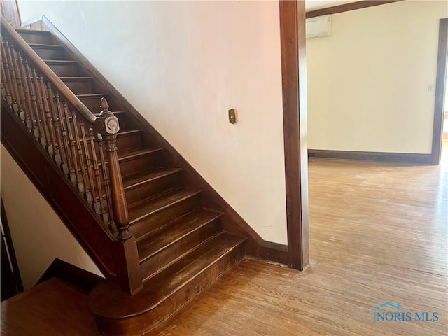 staircase featuring baseboards and wood finished floors
