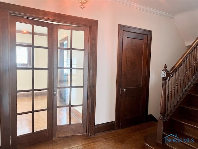 doorway to outside featuring ornamental molding, baseboards, dark wood-style floors, and stairs