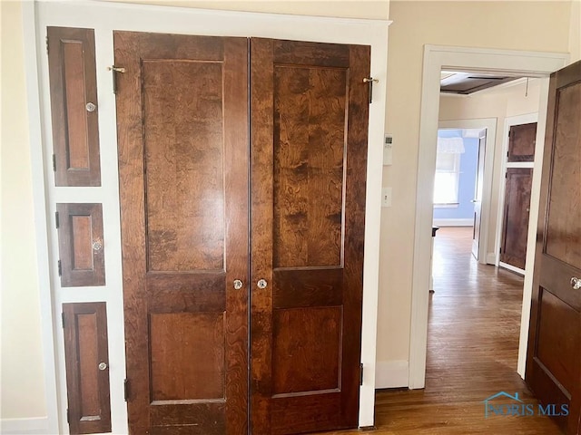 corridor with wood finished floors and baseboards