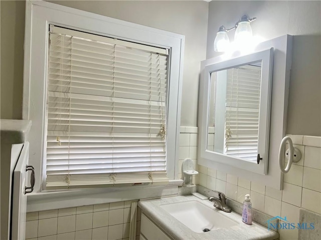 bathroom with washer / clothes dryer, vanity, and tile walls