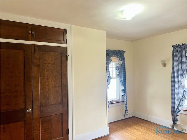 unfurnished bedroom with baseboards and light wood-style floors