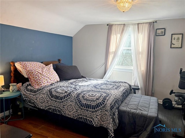 bedroom with wood finished floors, baseboards, and vaulted ceiling