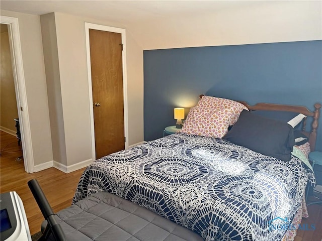bedroom featuring baseboards and wood finished floors