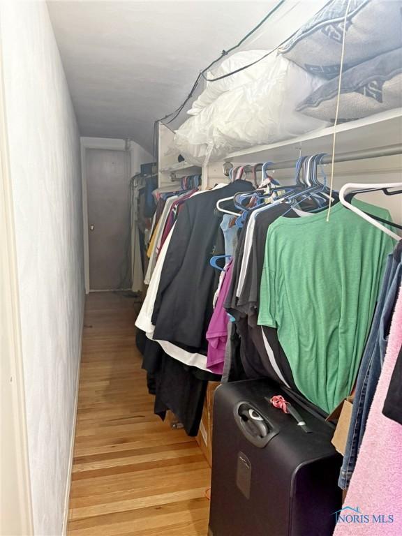 walk in closet with wood finished floors