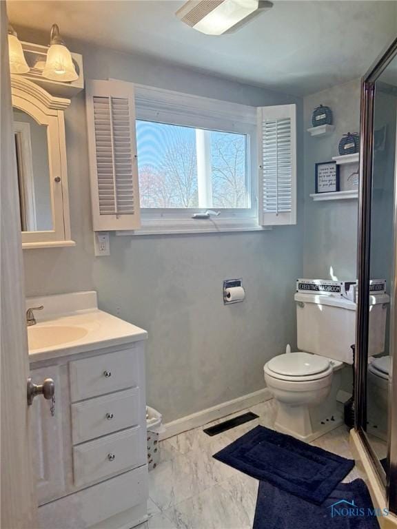 bathroom featuring toilet, vanity, and baseboards