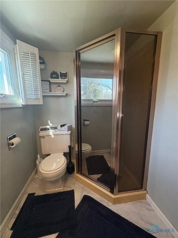 bathroom with toilet, a shower stall, and marble finish floor