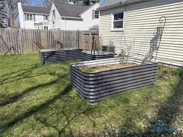 view of yard featuring central air condition unit, fence, and a vegetable garden