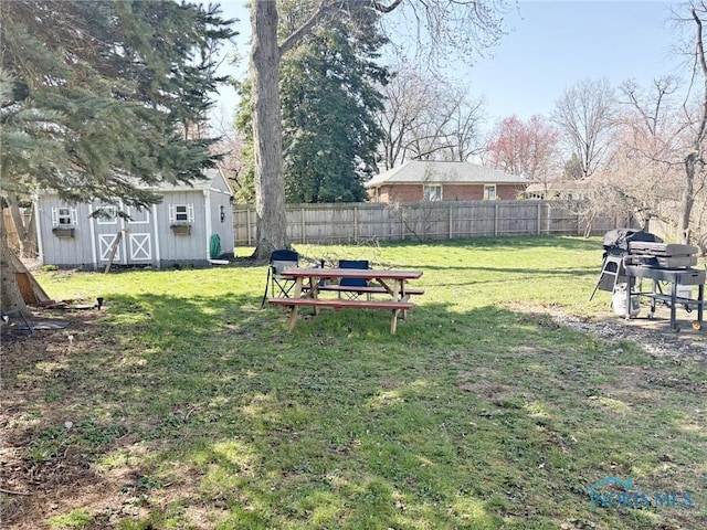 view of yard with a shed, an outdoor structure, and fence