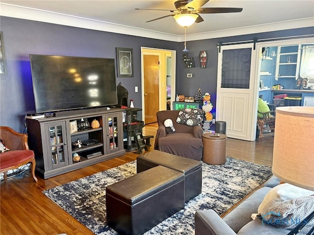 living area with a barn door, a ceiling fan, and wood finished floors